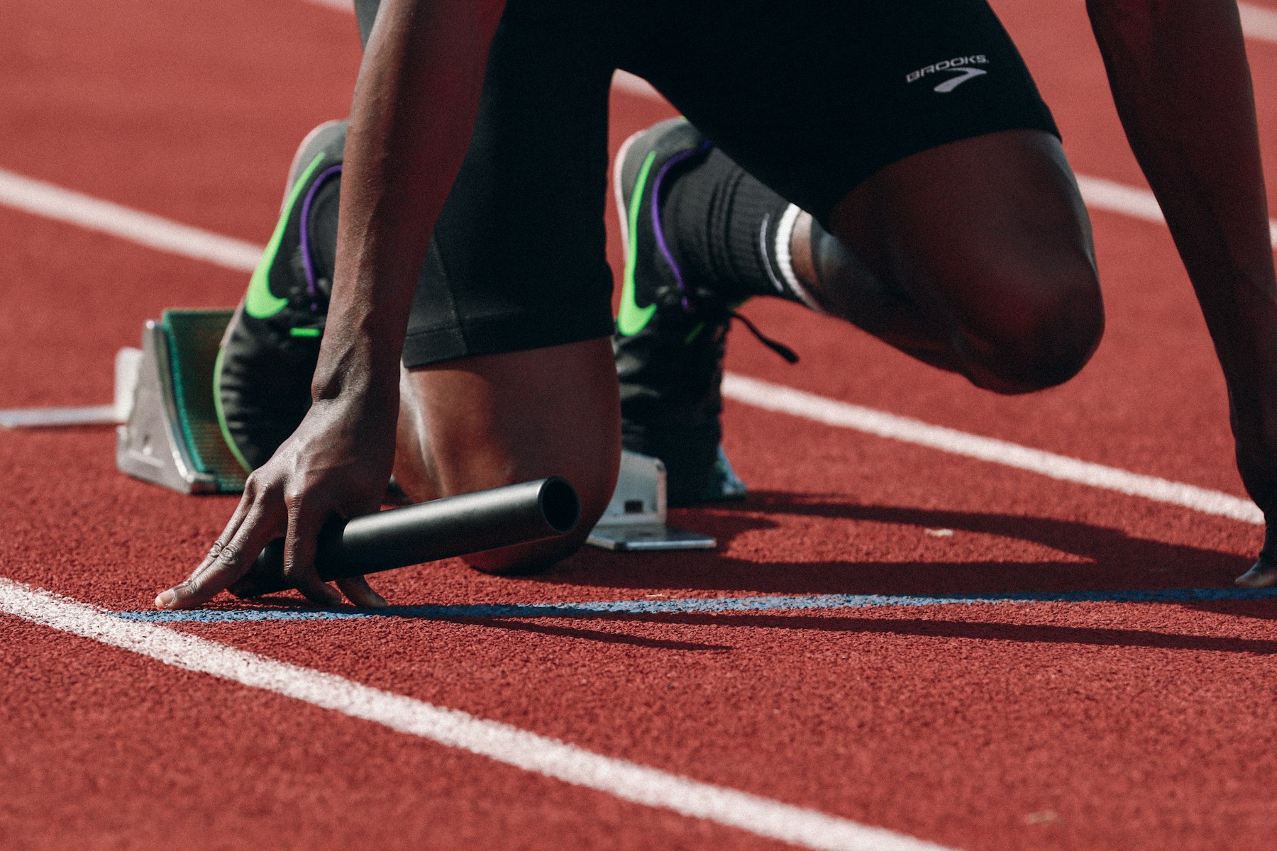 Mà d'un atleta amb el testimoni, a la sortida d'un relleu